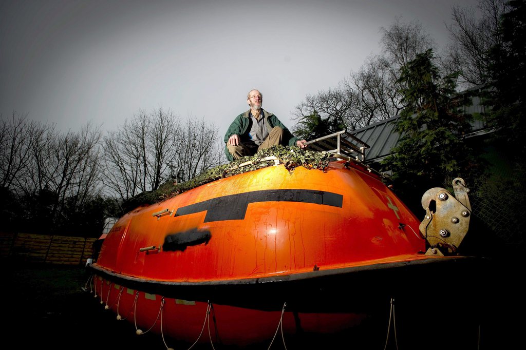 epa03514294 Dutch Pieter van der Meer poses on his Norwegian lifeboat lying in his garden in Kootwijkerbroek, The Netherlands, 19 December 2012. Thirty-five persons will take refuge in the boat to survive a coming global apocalypse, which according to an ancient Maya calender should happen on 21 December. The Mayan calendar marks the end of a cicle on 21 December 2012, sparking a controversy if this is the announcement of the end of the world or the change of an era.  EPA/ROBIN VAN LONKHUIJSEN