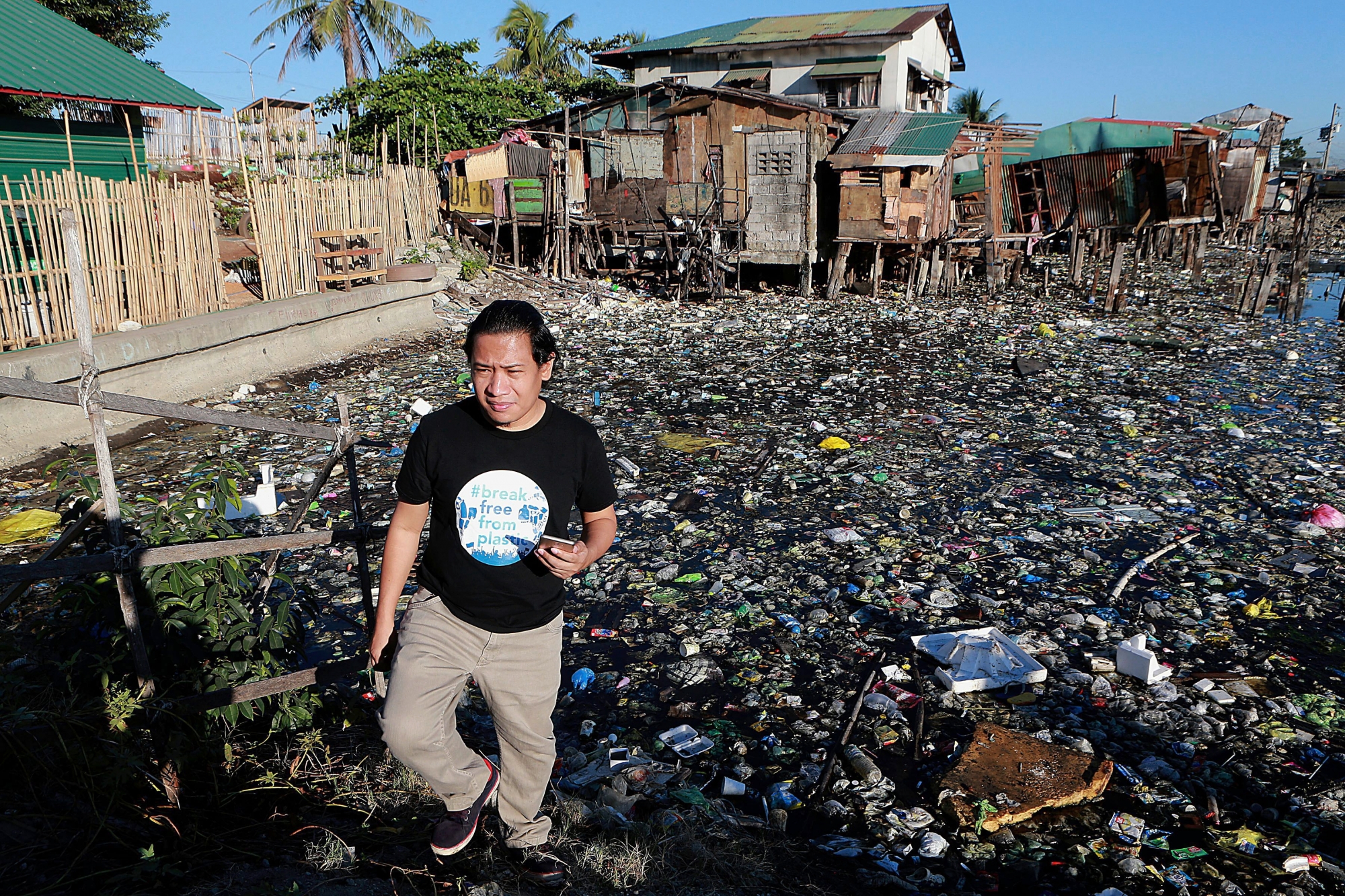 Global Anti Incineration Alliance Philippines Executive Director Froilan Grate walks on a trash-filled river in Barangay Bagumbayan North in Navotas City, Philippines. GP0STT1XY