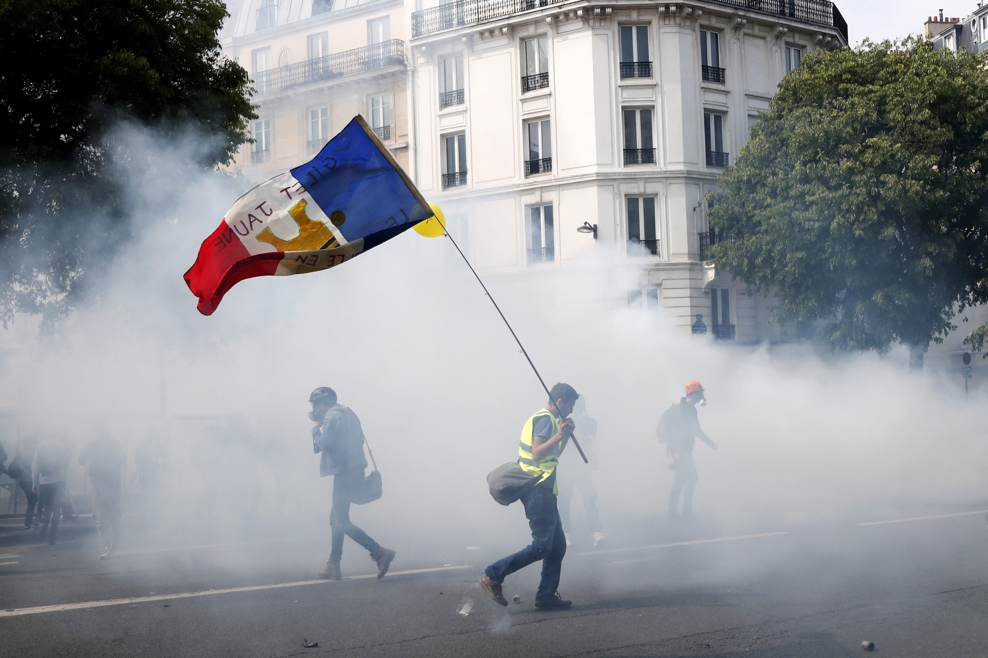 epa07540340 A 'Gilets Jaunes' (Yellow Vests) protester holds a French flag during a demonstration of the French trade unions members and the 'Gilets Jaunes' (Yellow Vests) movement marking Labor Day in Paris, France, 01 May 2019.  EPA/IAN LANGSDON FRANCE LABOR DAY PROTEST