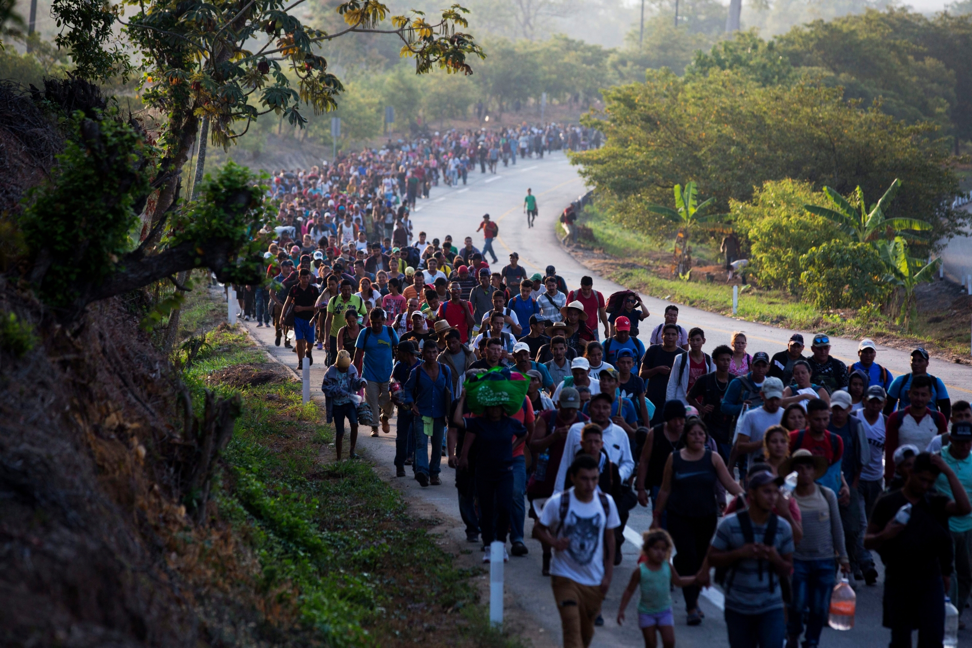 FILE - In this April 20, 2019, file photo, Central American migrants, part of a caravan hoping to reach the U.S. border, move on the road in Escuintla, Chiapas state, Mexico. The number of migrants apprehended at the Southern border topped 100,000 for the second month in a row, as the Trump administration manages an ever increasing number of Central American families streaming to the U.S. (AP Photo/Moises Castillo, File) Border Woes