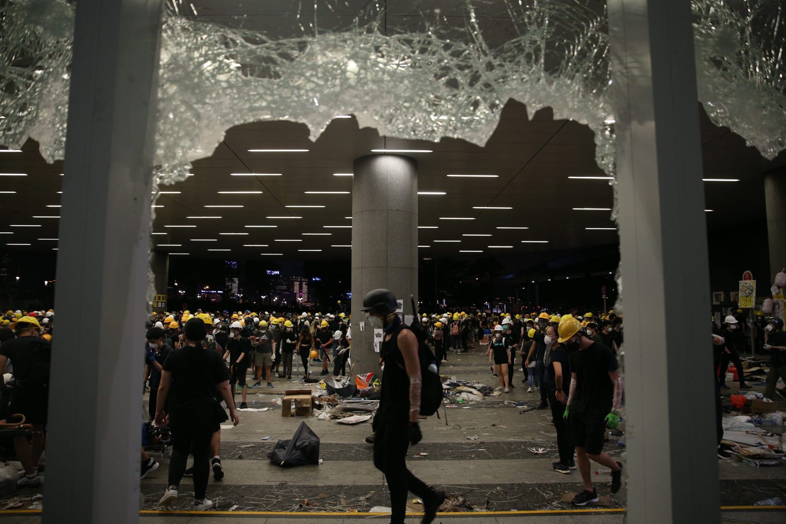 epa07687529 Protesters are seen through broken glass panels after they break into the Legislative Council building during the annual 01 July pro-democracy march in Hong Kong, China, 01 July 2019. Protesters are demanding the resignation of Hong Kong Chief Executive Carrie Lam and the full withdrawal of a suspended extradition bill. On 01 July, Hong Kong marks the 1997 transfer of sovereignty of Hong Kong from Britain to China.  EPA/JEROME FAVRE CHINA HONG KONG EXTRADIITON BILL
