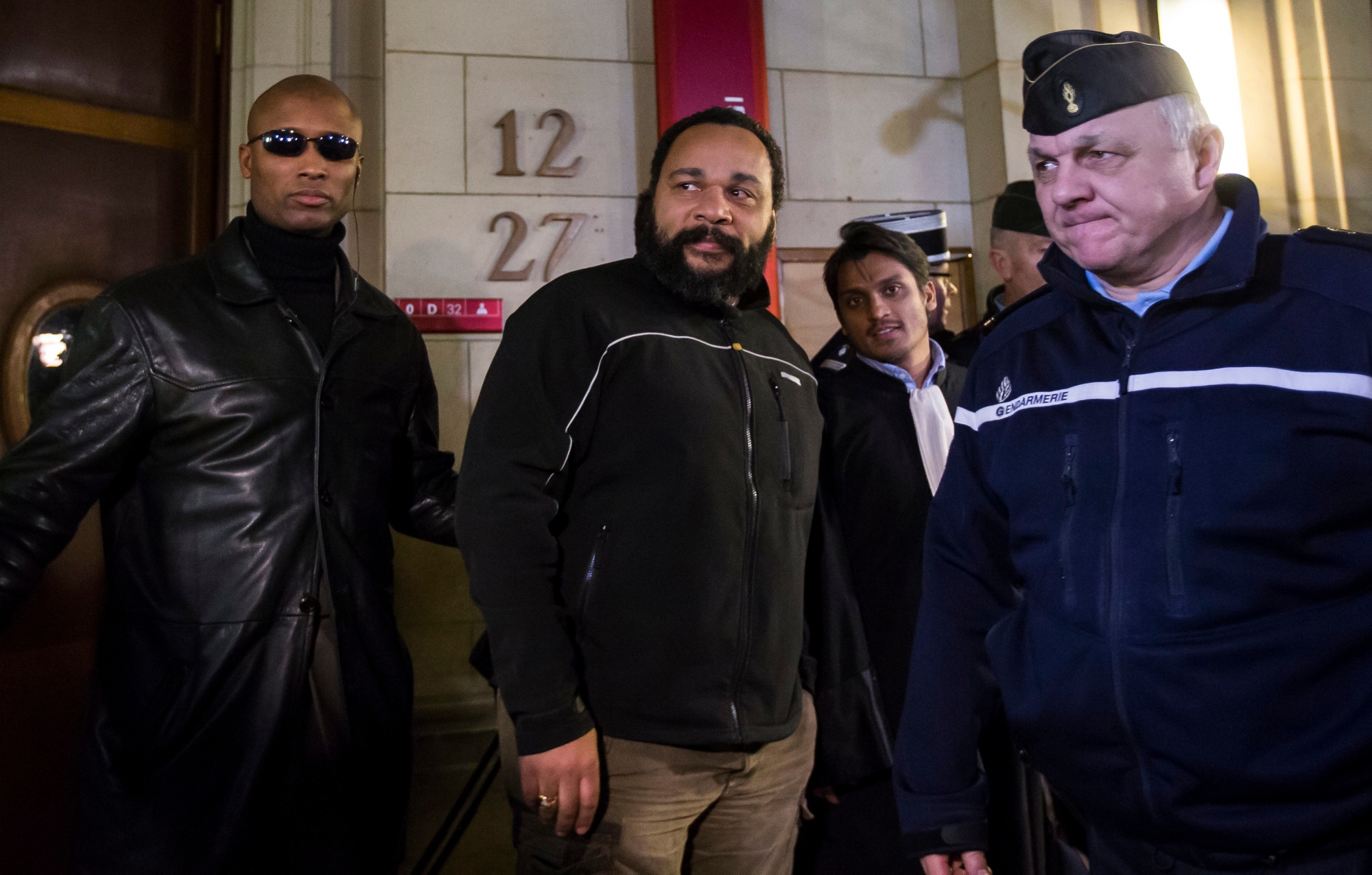 epa04603754 French comedian Dieudonne M'Bala M'Bala (C) exits the courtroom after his trial at the Court House, in Paris, France, 04 February 2015. Controversial comedian Dieudonne M'Bala M'Bala stands trial on charges of advocating terrorism after posting on a social network profile the comment 'I feel like Charlie Coulibaly', in reference to the 'I am Charlie' slogan made popular in the wake of the 07 January terror attack on the satirical Charlie Hebdo newspaper headquarters in Paris. The comment appeared to support one of the three gunmen, Amedy Coulibaly.  EPA/IAN LANGSDON FRANCE TRIALS