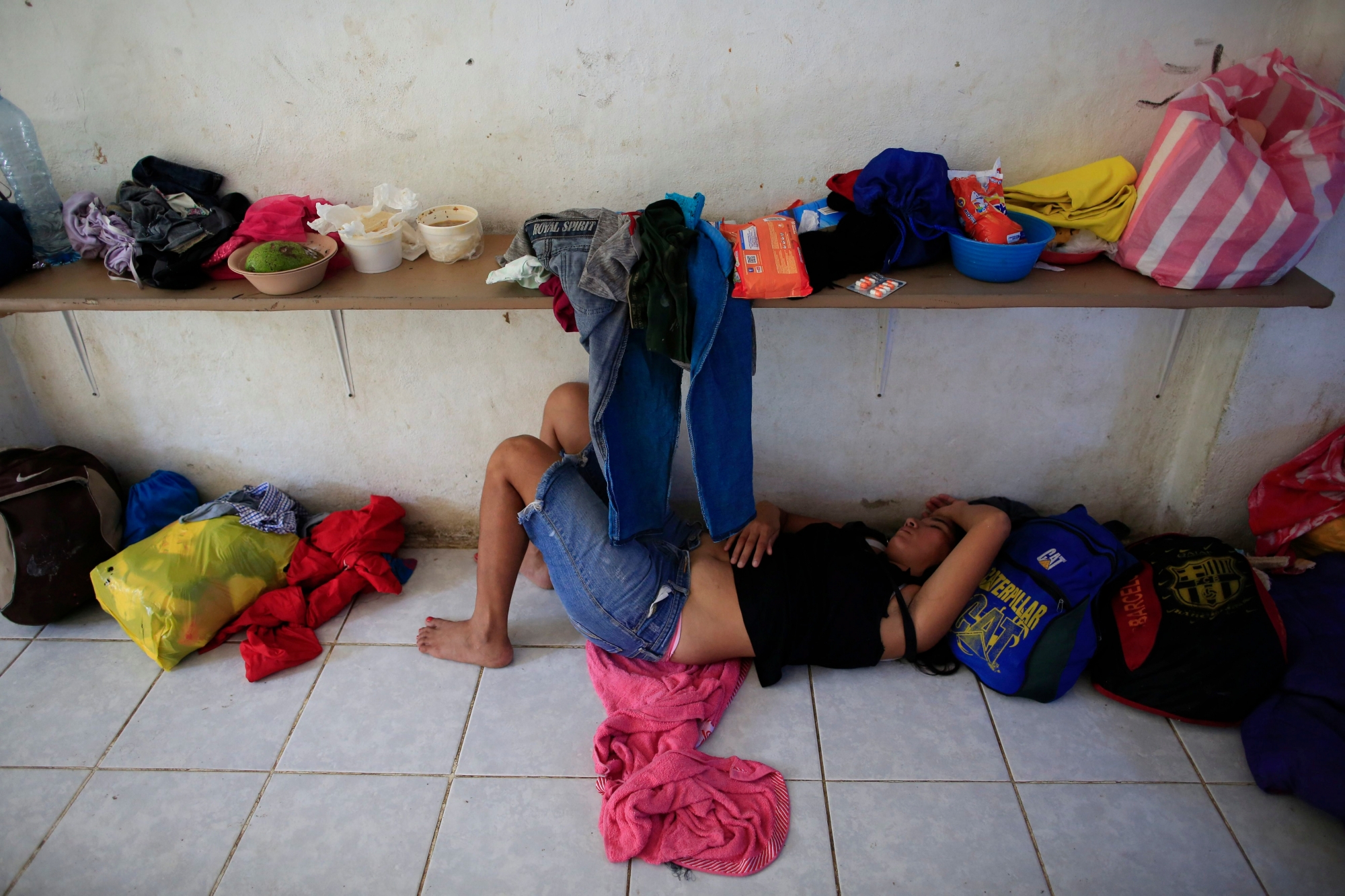 A woman naps on the tile floor of a room converted into a dormitory at the Good Shepherd migrant shelter in Tapachula, Mexico, Tuesday, June 18, 2019. Mexico's ramped-up effort to curb the flow of Central American migrants to the United States so far hasn't eased the burden on the dozens of independent humanitarian shelters like Good Shepherd that are scattered along migration routes through the country. (AP Photo/Rebecca Blackwell) Mexico Immigration
