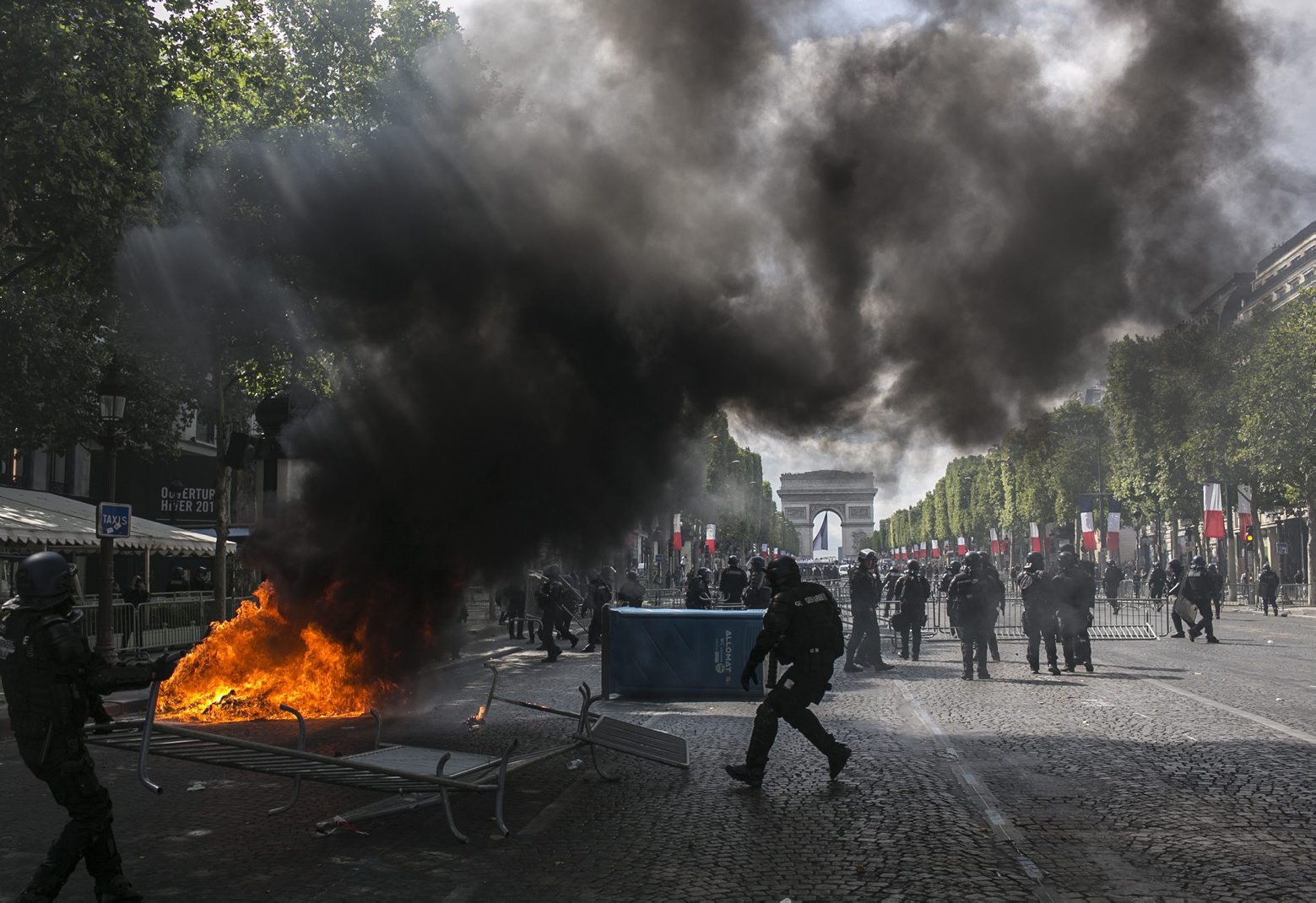 Riot police officers take position on the Champs-Elysees avenue during scuffles with demonstrators after Bastille Day parade Sunday, July 14, 2019 in Paris. (AP Photo/Rafael Yaghobzadeh) APTOPIX France Bastille Day