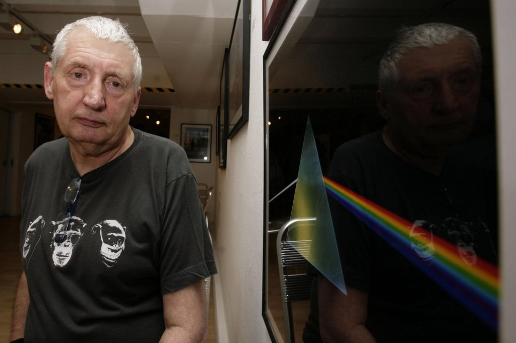 FILE - This July 24, 2008 file photo shows English graphic designer Storm Thorgerson standing next to his album cover artwork for Pink Floyd's "The Dark Side of the Moon" during the opening of his exhibition 'Mind Over Matter: The Images of Pink Floyd' in London. Storm Thorgerson whose eye-catching Pink Floyd and Led Zeppelin album covers captured the spirit of 1970s psychedelia, has died. He was 69. In a statement, Thorgerson?s family said that he died Thursday April 18, 2013 and that ?his ending was peaceful and he was surrounded by family and friends.? (AP Photo/PA, Yui Mok, File) UNITED KINGDOM OUT  NO SALES  NO ARCHIVE