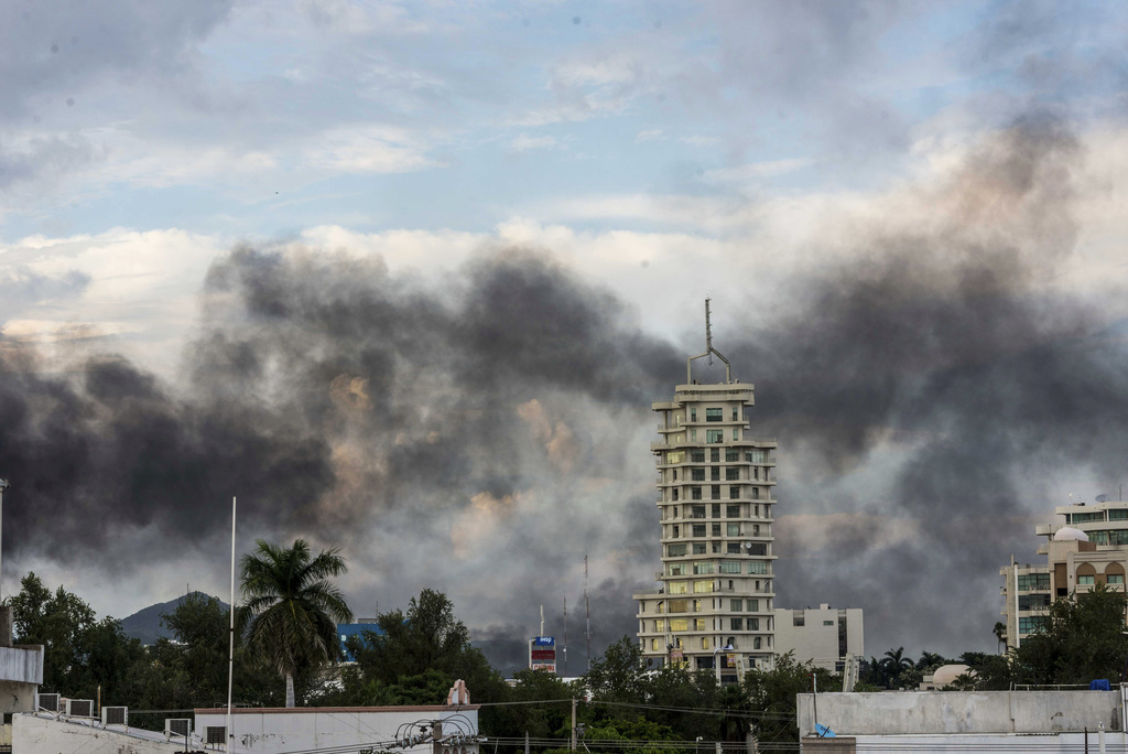 Smoke from burning cars rises due in Culiacan, Mexico, Thursday, Oct. 17, 2019. An intense gunfight with heavy weapons and burning vehicles blocking roads raged in the capital of Mexico&#x201a;Äôs Sinaloa state Thursday after security forces located one of Joaqu??n &#x201a;ÄúEl Chapo&#x201a;Äù Guzm?°n&#x201a;Äôs sons who is wanted in the U.S. on drug trafficking charges. (AP Photo/Hector Parra)