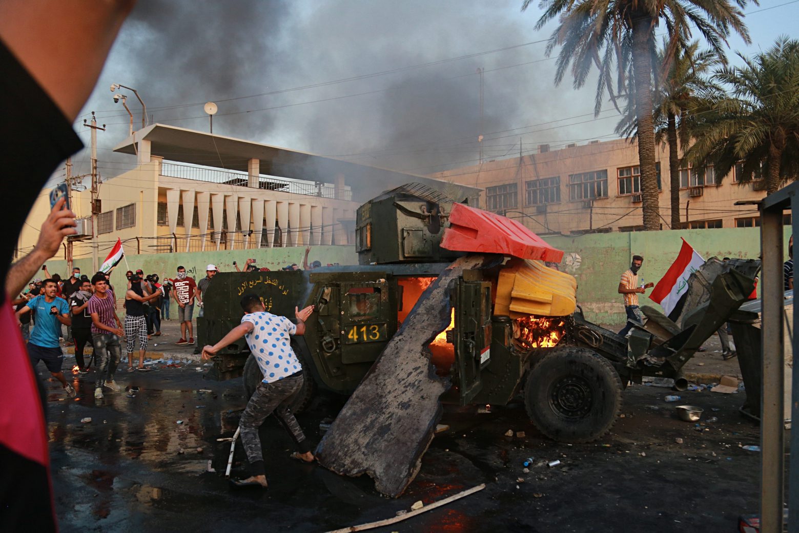 Anti-government protesters burn an armored vehicle belonging to the Federal Police Rapid Response Forces during a protest in Baghdad, Iraq, Thursday, Oct. 3, 2019. Iraqi security forces fired live bullets into the air and used tear gas against a few hundred protesters in central Baghdad on Thursday, hours after a curfew was announced in the Iraqi capital on the heels of two days of deadly violence that gripped the country amid anti-government protests that killed over 19 people in two days. (AP Photo/Hadi Mizban) Iraq Protests
