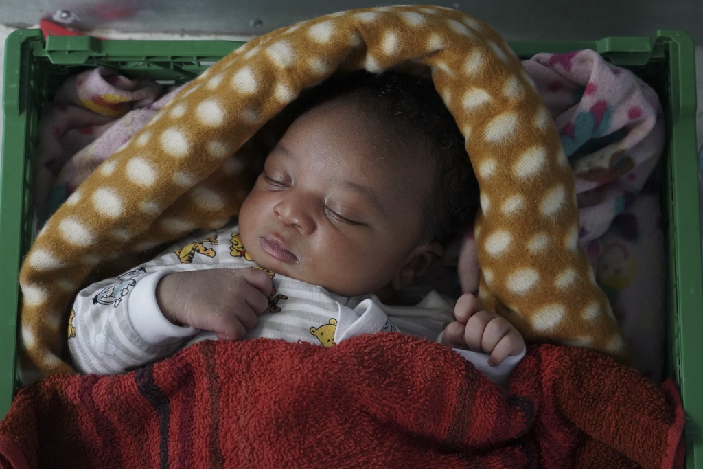Ange, a 5-day-old newborn baby from Cameroon sleeps inside the women's shelter of the Ocean Viking humanitarian rescue ship in the Mediterranean Sea, Wednesday, Sept. 18, 2019. The baby, his mother and two brothers were among 109 people rescued on Tuesday by the Norwegian-flagged ship operated by SOS Mediterranee and Doctors Without Borders. (AP Photo/Renata Brito)
