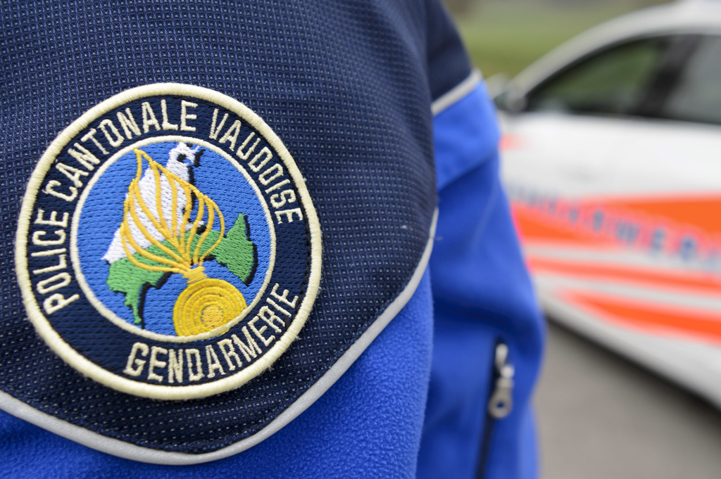 [Editor's note: photo mise-en-scene] Detail view of the uniform of a police officer of the cantonal police of Vaud, in the foreground, and a police car, in the background, photographed in Cugy, in the Canton of Vaud, Switzerland, on November 3, 2015. (KEYSTONE/Laurent Gillieron)  [Editor's note: photo mise-en-scene] Un policier (gendarme) du corps de gendarmerie de la Police cantonale vaudoise photographie proche d'une voiture de police ce mardi 3 novembre 2015 a Cugy, Vaud. (KEYSTONE/Laurent Gillieron)