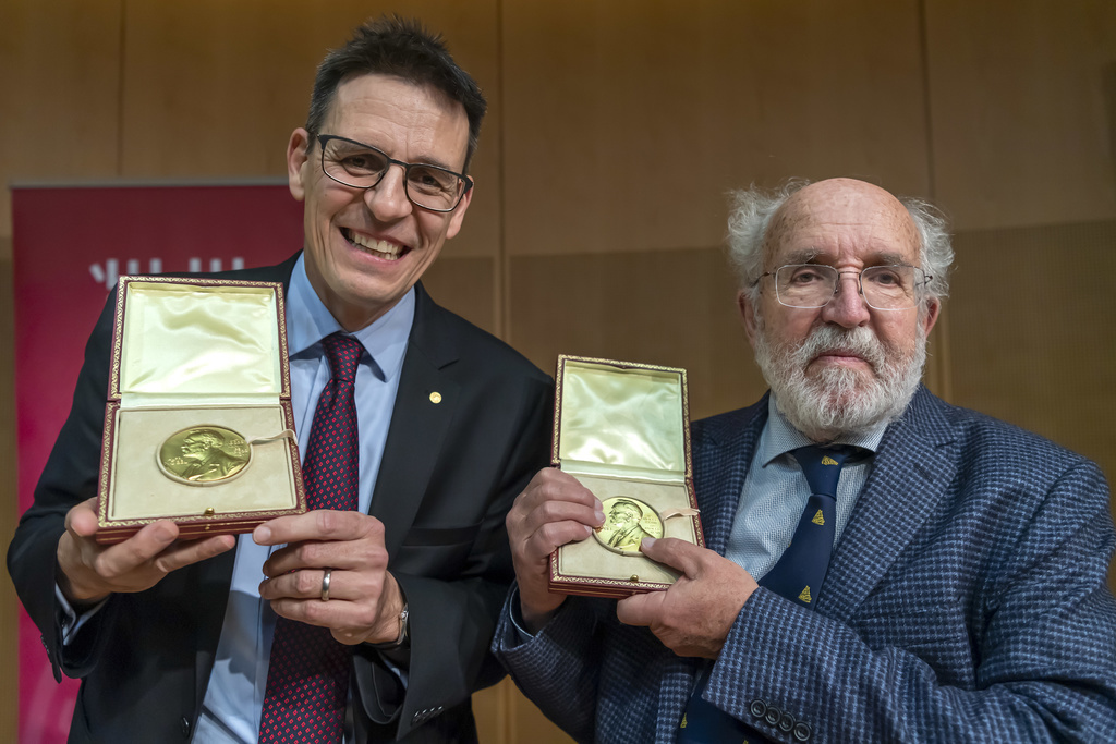 Laureats du prix Nobel de physique Didier Queloz, gauche, et Michel Mayor, droite, posent avec leurs medailles apres leur descentes de l'avion qui les ramene de Stockholm en suede, ce samedi 14 decembre 2019 a l'aeroport international de Geneve (AIG). (KEYSTONE/Martial Trezzini)