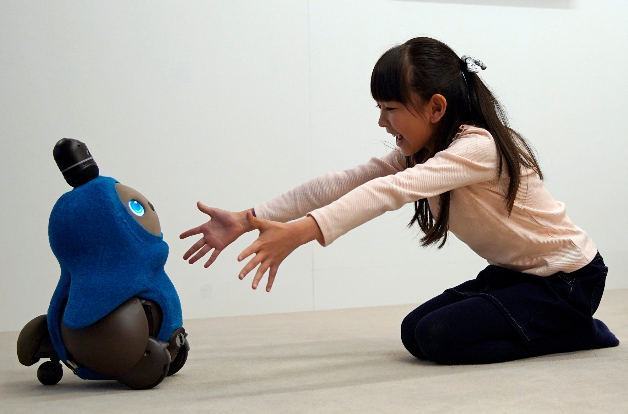 epa07238033 A young girl reaches out to GROOVE X's new home robot 'LOVOT' during its presentation at a press event in Tokyo, Japan, 18 December 2018. The company is taking orders starting 18 December and first delivery to costumers are scheduled in autumn 2019. The duo version with two LOVOT robots will be on sale at around 5,000 euros.  EPA/FRANCK ROBICHON JAPAN TECHNOLOGY LOVOT ROBOT
