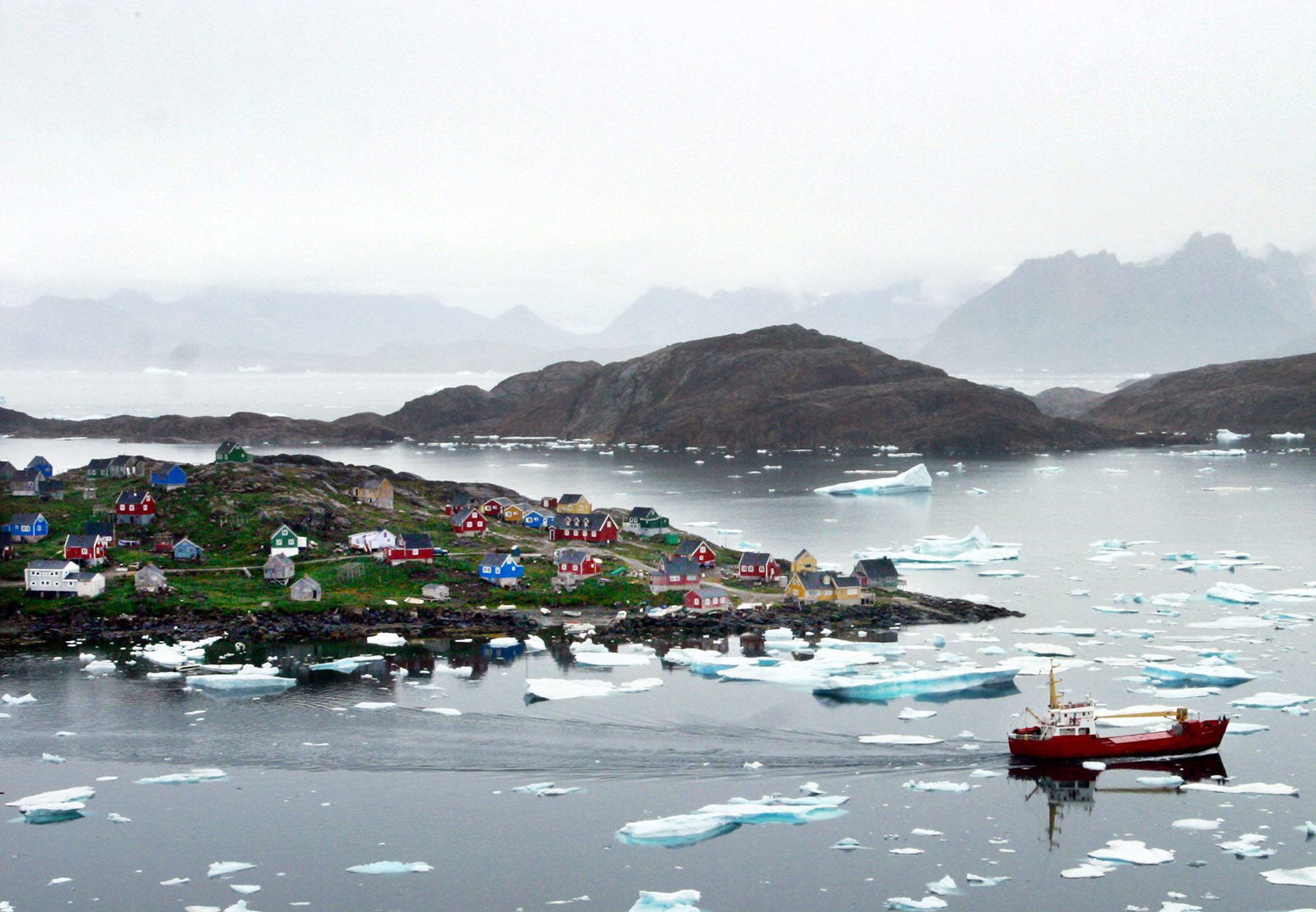 Un bateau de pecheur cherche son chemin a travers les icebergs pres de la cote de Kulusuk, au Groenland, le 15 aout 2005. 

(KEYSTONE/AP Photo/John McConnico)  ** zu unserem Korr APD3256 ** GROENLAND