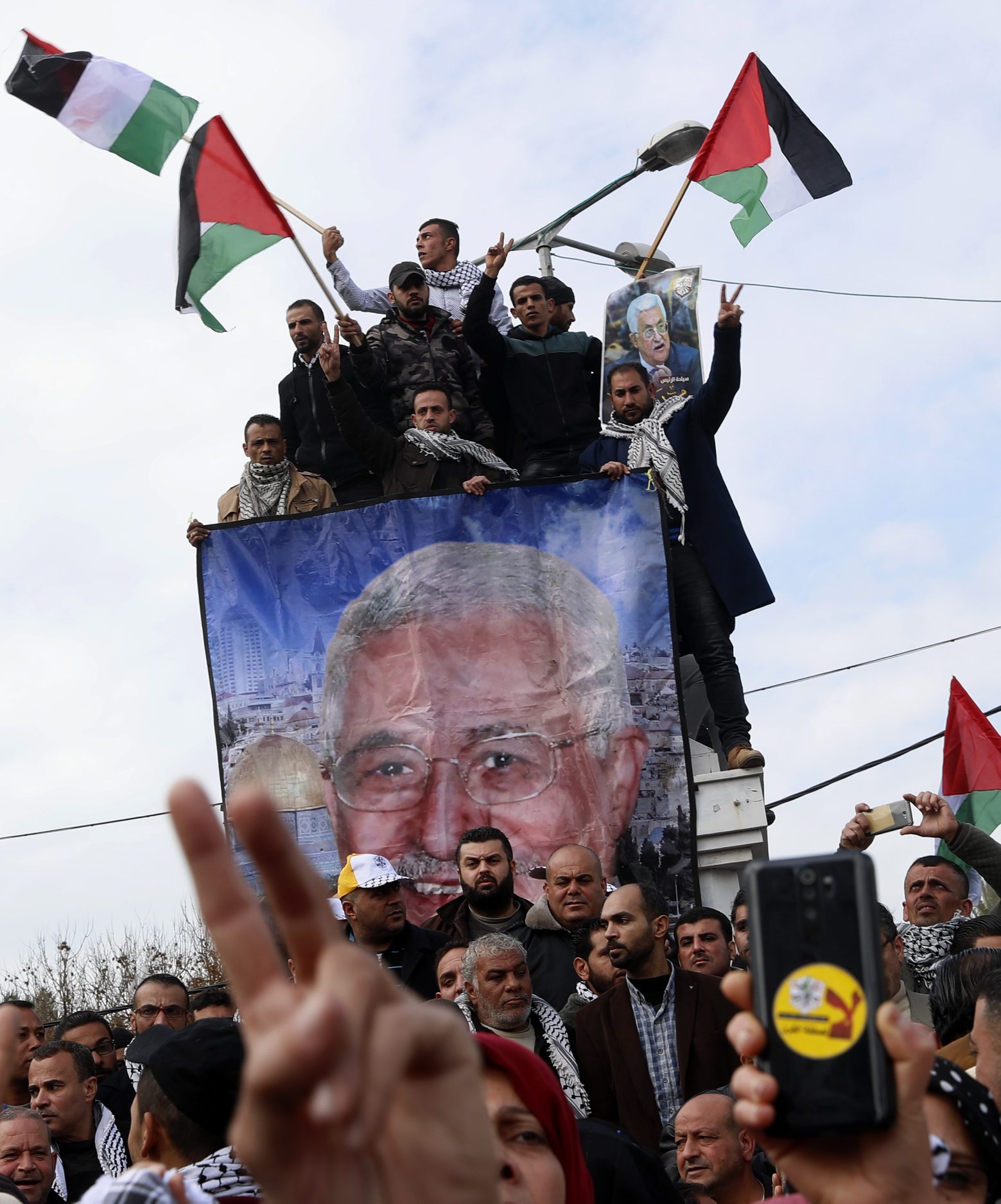 Protestors wave Palestinian flags during a rally supporting Palestinian President Mahmoud Abbas, shown in banner, and against the Mideast plan announced by U.S. President Donald Trump, at the Unknown Soldier Square in Gaza City, Tuesday, Feb. 11, 2020. (AP Photo/Adel Hana) Palestinians Israel US