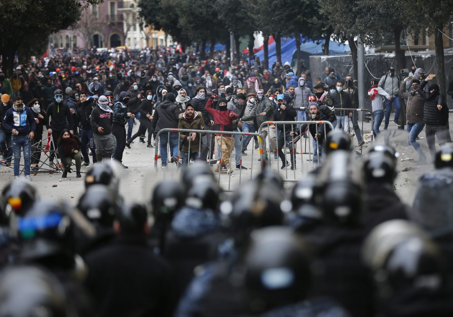 Anti-government protesters clash with riot police in downtown Beirut, Lebanon,Tuesday, Feb. 11, 2020. Lebanese security forces fired tear gas to disperse thousands of protesters near the parliament building in Beirut, where the new Cabinet was expanding on its policy statement on Tuesday ahead of a confidence vote by lawmakers. (AP Photo/Hussein Malla) Lebanon Protests