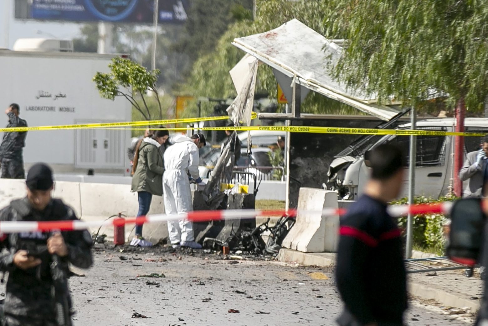 Forensic officers work on a blast site near the US Embassy in Tunis, Friday, March 6, 2020. Tunisian media are reporting that two people on a motorcycle have set off a blast near the U.S. Embassy in the capital Tunis, the private Radio Mosaique said that five police officers were wounded and described it as a suicide attack. (AP Photo/Riadh Dridi) Tunisia Explosion