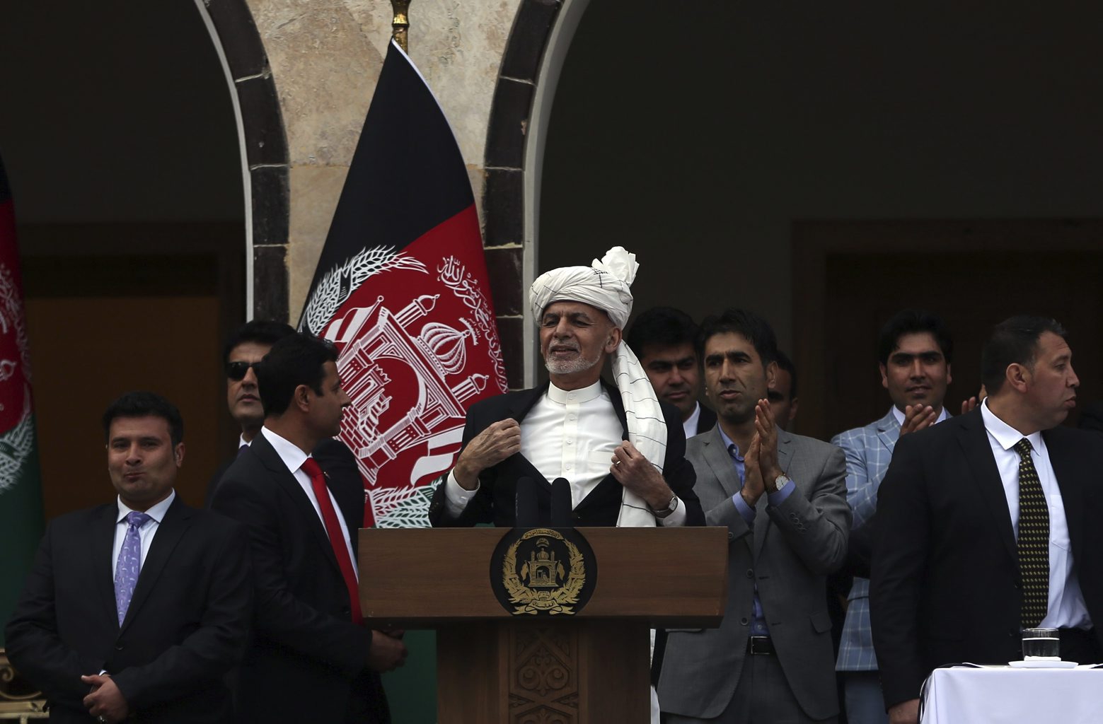 Afghan President Ashraf Ghani, center, opens his coat after a few rockets are fired during his speech after being sworn in at his inauguration ceremony at the presidential palace in Kabul, Afghanistan, Monday, March 9, 2020. (AP Photo/Rahmat Gul) Afghanistan
