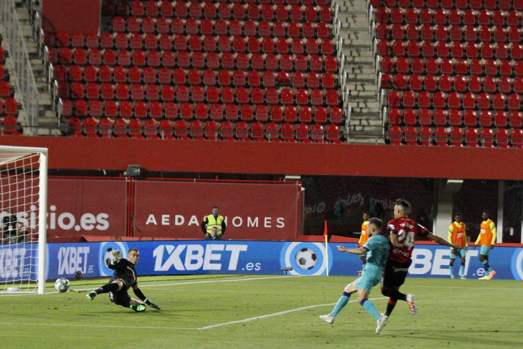 Le Barcelonais Jordi Alba (en vert) marque devant des tribunes vides.