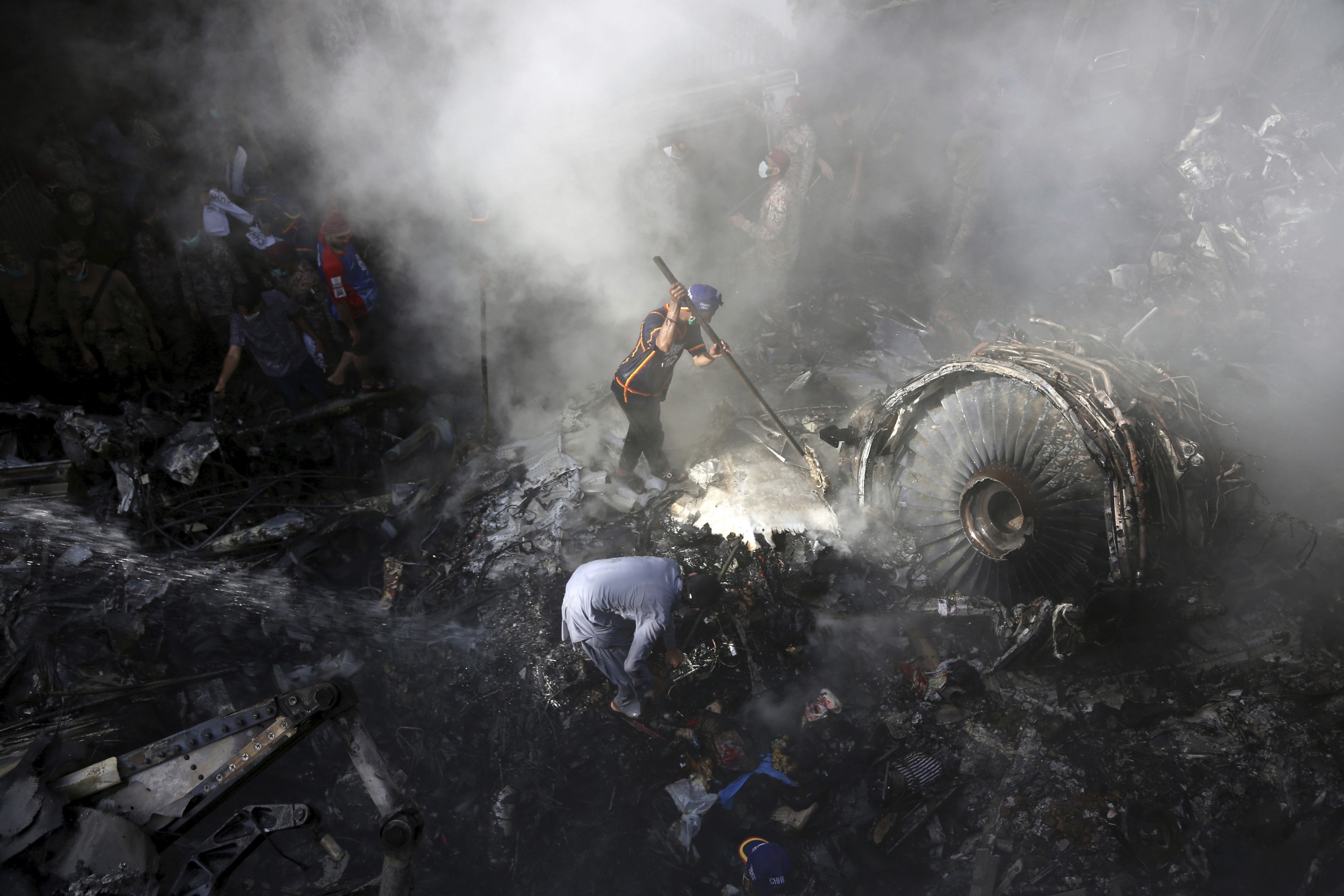 Volunteers look for survivors of a plane that crashed in residential area of Karachi, Pakistan, May 22, 2020. An aviation official says a passenger plane belonging to state-run Pakistan International Airlines carrying more than 100 passengers and crew has crashed near the southern port city of Karachi. (AP Photo/Fareed Khan) Pakistan Plane Crash