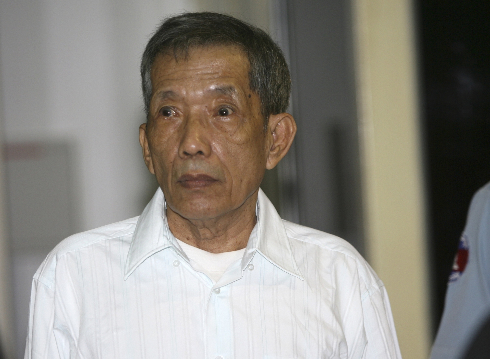 FILE - In this March 30, 2020, file photo, former Khmer Rouge prison chief Kaing Guek Eav, also know as Duch, looks on during the first day of a U.N.-backed tribunal in Phnom Penh, Cambodia. The Khmer Rouge‚Äôs chief jailer, who admitted overseeing the torture and killings of as many as 16,000 Cambodians while running the regime‚Äôs most notorious prison, died at a hospital in Cambodia early Wednesday morning, Sept. 2, 2020. Kaing Guek Eav, known as Duch, was 77 and had been serving a life prison term for war crimes and crimes against humanity. (Mak Remissa/Pool Photo via AP, File) Kaing Guek Eav Duch ArcInfo