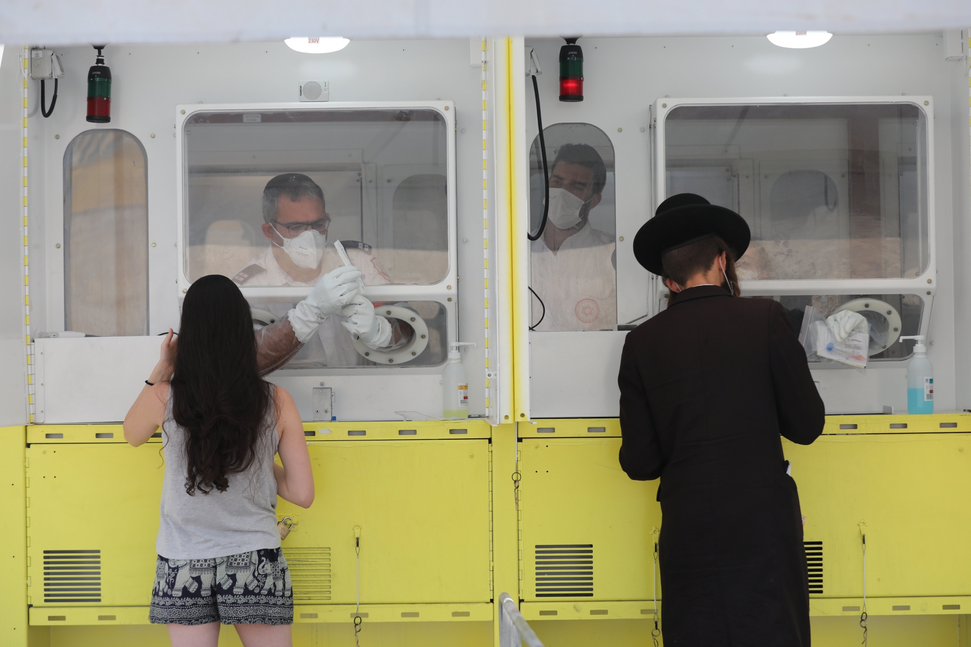 epa08650122 An Ultra orthodox Jewish man (R) and a woman (L) perform coronavirus tests at the Magen David Adom position in Jerusalem, 06 September 2020. Media report that the coronavirus COVID-19 death toll in Israel has passed 1,000. The rate of morbidity and spread of the virus in relation to the number of citizens is among the highest in the world, what led to another restrictions wave of the government to  impose a full closure of 30 cities in Israel in order to prevent the coronavirus COVID-19 outbreak.  EPA/ABIR SULTAN ArcInfo